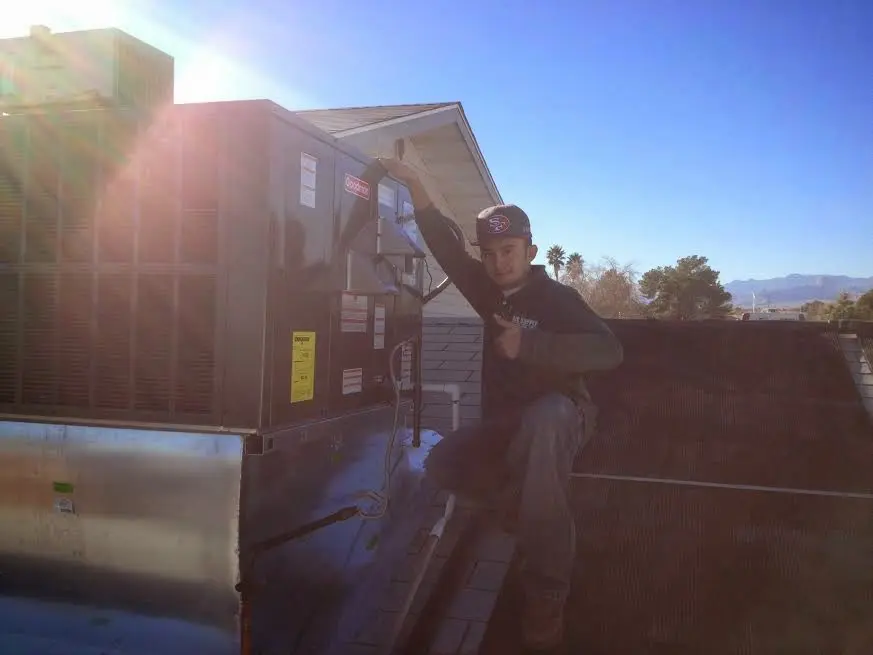 HVAC technician performing Heat Pump Repair on a rooftop unit in Mendon